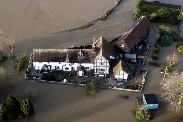 بريطاني يتغلّب على فيضانات العاصفة «هينك».. ماذا فعل بمنزله؟