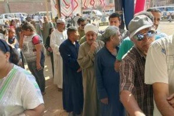 ناخبون يصطفون في طوابير أمام مدرسة بأسوان لتصويتهم.